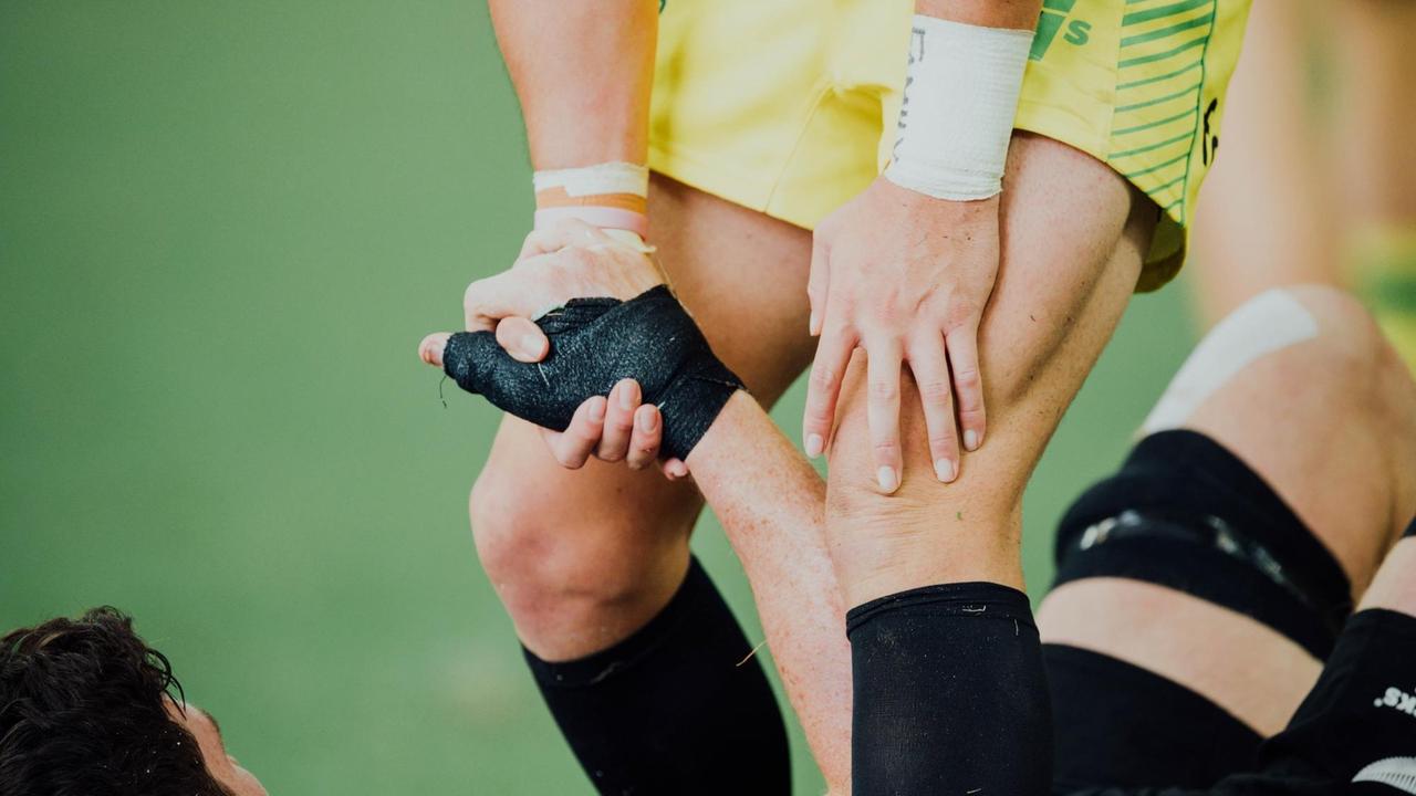 Eine Person hilft einer anderen beim Sport vom Boden auf. Eine Person hilft einer anderen beim Sport vom Boden auf.