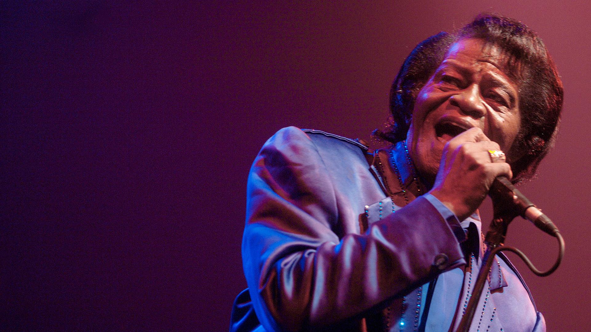 Der Soulsänger James Brown bei einem Auftritt am Mikrofon.