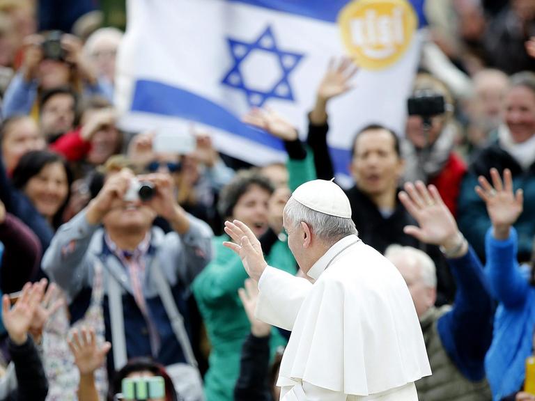 Papst Franziskus in Rom bei einer Audienz, im Hintergrund eine Flagge Israels.