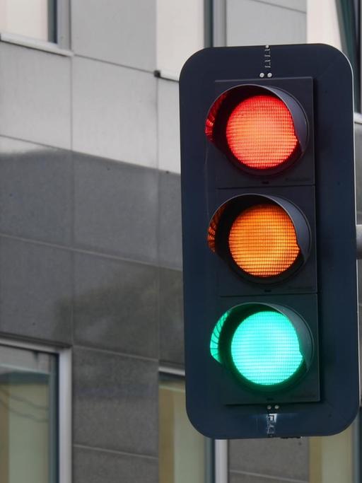 Eine Ampel, an der für einen Moment die Farben rot, gelb und grün gleichzeitig zu leuchten scheinen, ist am Tag nach der Bundestagswahl im Regierungsviertel zu sehen.