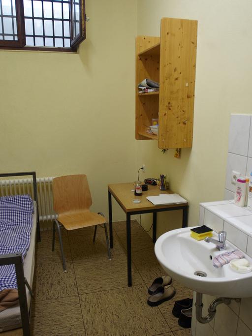 Ein Haftraum in der Justizvollzugsanstalt Koblenz am 01.12.2011 mit Schrank, Bett, Tisch, Stuhl, Regal und Waschbecken.