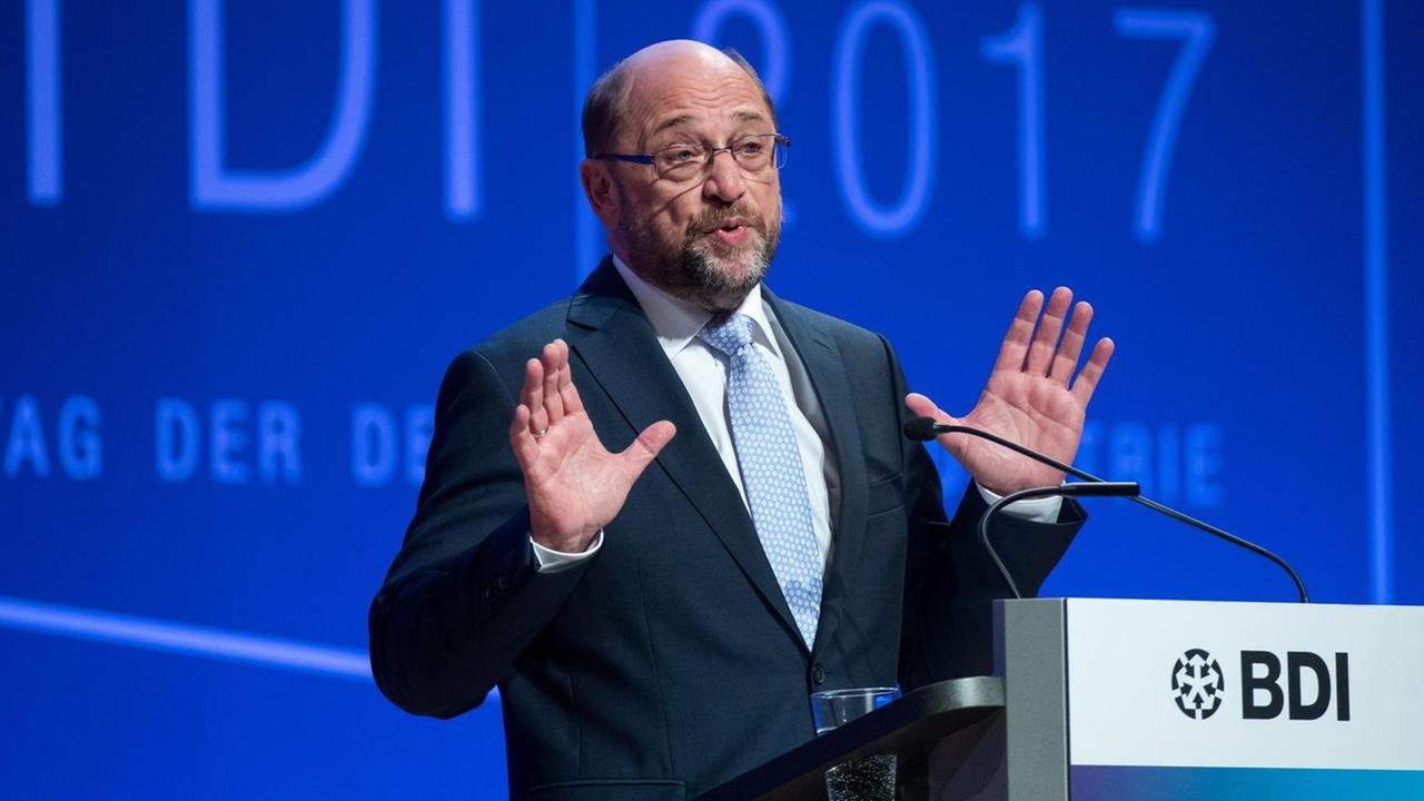 Martin Schulz am Rednerpult mit erhobenen Händen vor einer blauen Wand Martin Schulz am Rednerpult mit erhobenen Händen vor einer blauen Wand