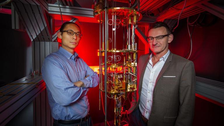 Henry Yang und Andrew Dzurak stehen vor ihrem Quantencomputer-Prototypen, der immerhin "nur" auf 1,5 Grad Kelvin heruntergekühlt werden muss. 