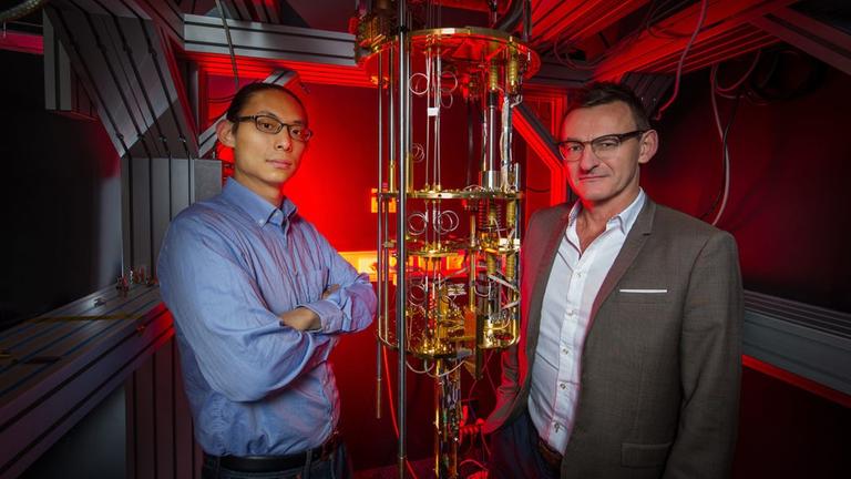 Henry Yang und Andrew Dzurak stehen vor ihrem Quantencomputer-Prototypen, der immerhin "nur" auf 1,5 Grad Kelvin heruntergekühlt werden muss. Henry Yang und Andrew Dzurak stehen vor ihrem Quantencomputer-Prototypen, der immerhin "nur" auf 1,5 Grad Kelvin heruntergekühlt werden muss.