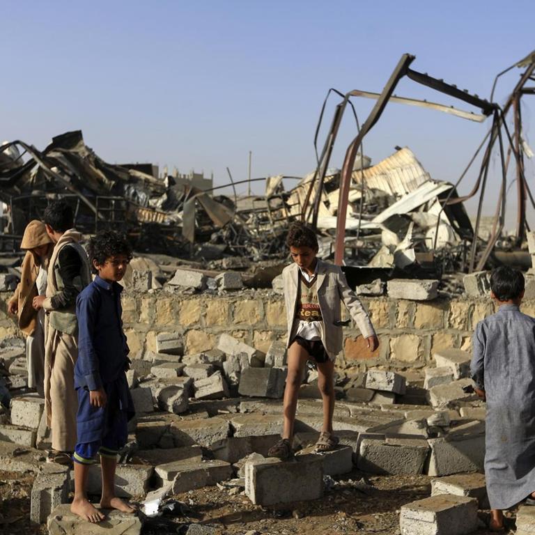 Kinder in der jemenitischen Hauptstadt Sanaa sammeln in Trümmern Metallteile auf, nachdem die von Saudi-Arabien angeführte Militärkoalition Luaftangriffe geflogen hat.