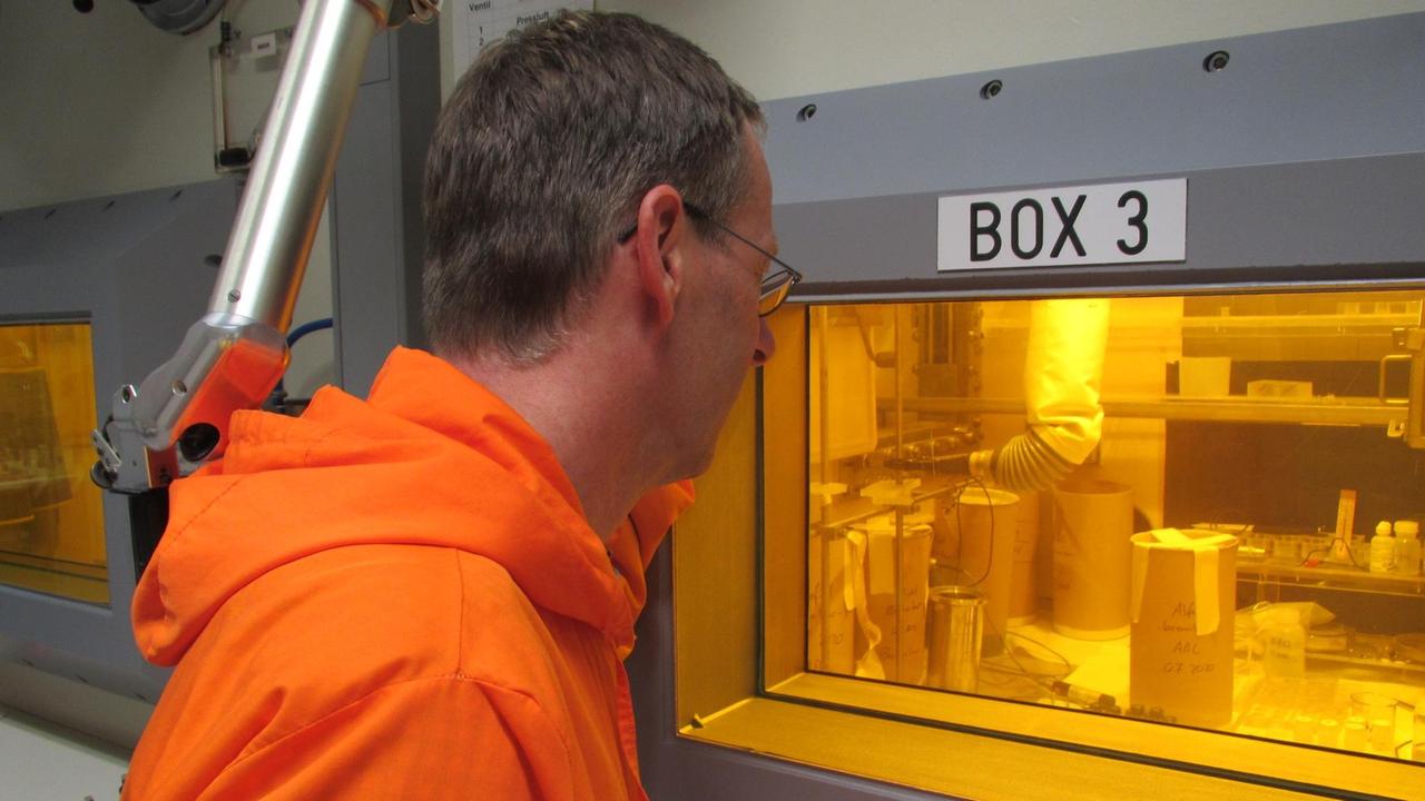 KIT-Forscher Volker Metz schaut in eine der durch Bleiglas abgeschirmten "heißen Zellen" im Strahlenlabor des KIT KIT-Forscher Volker Metz schaut in eine der durch Bleiglas abgeschirmten "heißen Zellen" im Strahlenlabor des KIT