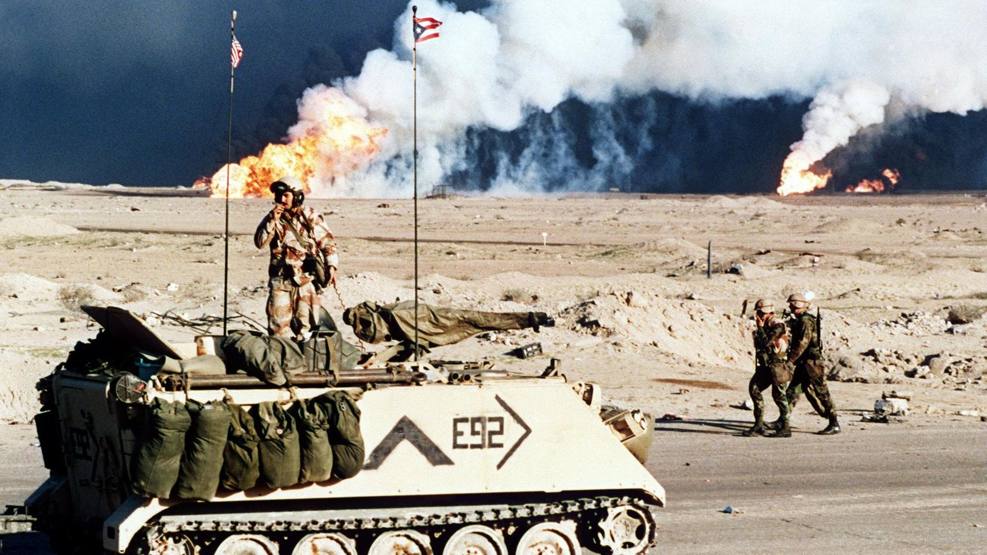 Ein amerikanischer Schützenpanzer vor brennenden Ölfeldern nahe der kuwaitisch-irakischen Grenze am 2.3.1991.