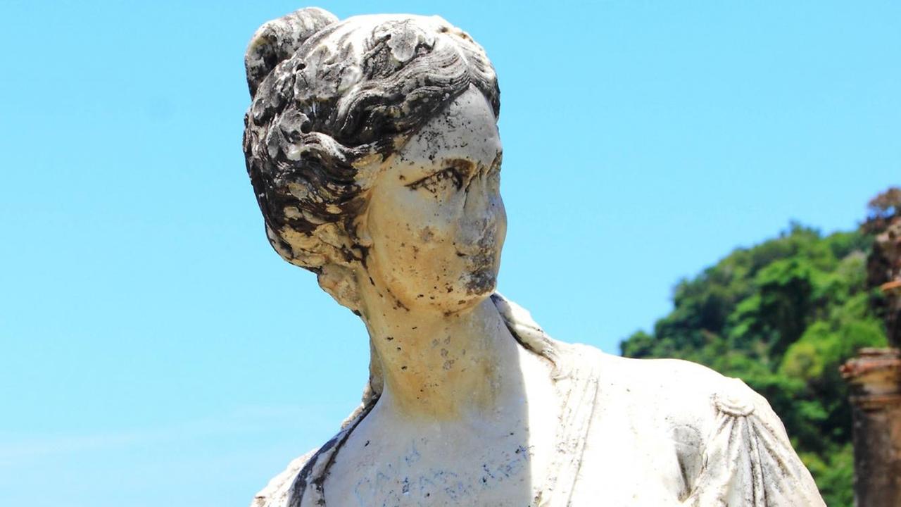 Eine von Altersspuren gezeichnete Statue einer Frau Eine von Altersspuren gezeichnete Statue einer Frau