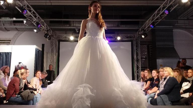 Ein Model führt ein Brautkleid auf einer Hochzeitsmesse vor Ein Model führt ein Brautkleid auf einer Hochzeitsmesse vor