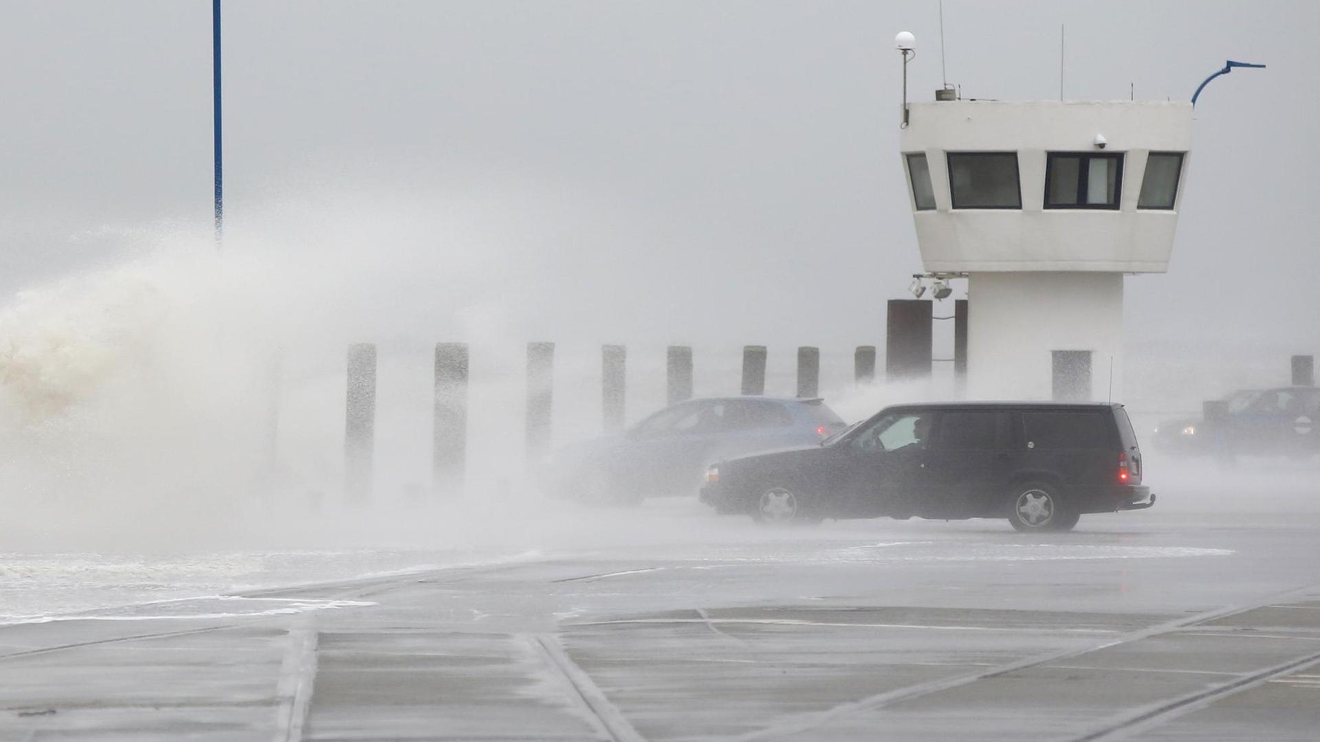 Eine Flut-Welle trifft geparkte Autos. Eine Flut-Welle trifft geparkte Autos.