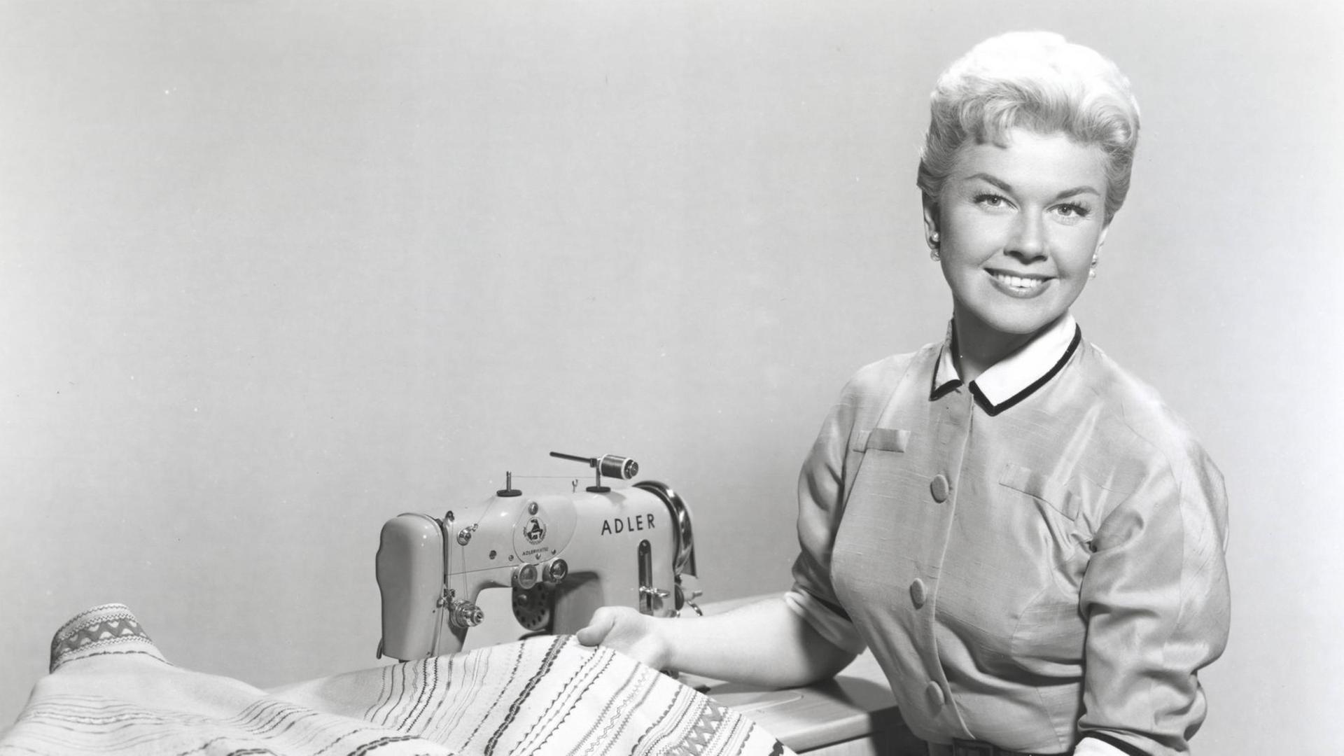 Doris Day sitzt um 1950 an einer Nähmaschine.