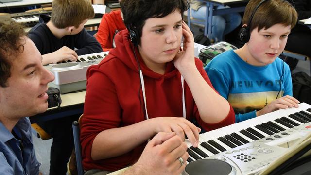  Sachsen, Pegau: An der Oberschule in Pegau üben Schülerinnen und Schüler der 7. Klasse im Musikunterricht eine Melodie am Keyboard. 