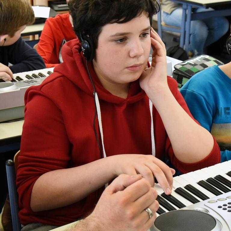 05.03.2018, Sachsen, Pegau: An der Oberschule in Pegau üben Schülerinnen und Schüler der 7. Klasse im Musikunterricht eine Melodie am Keyboard. 