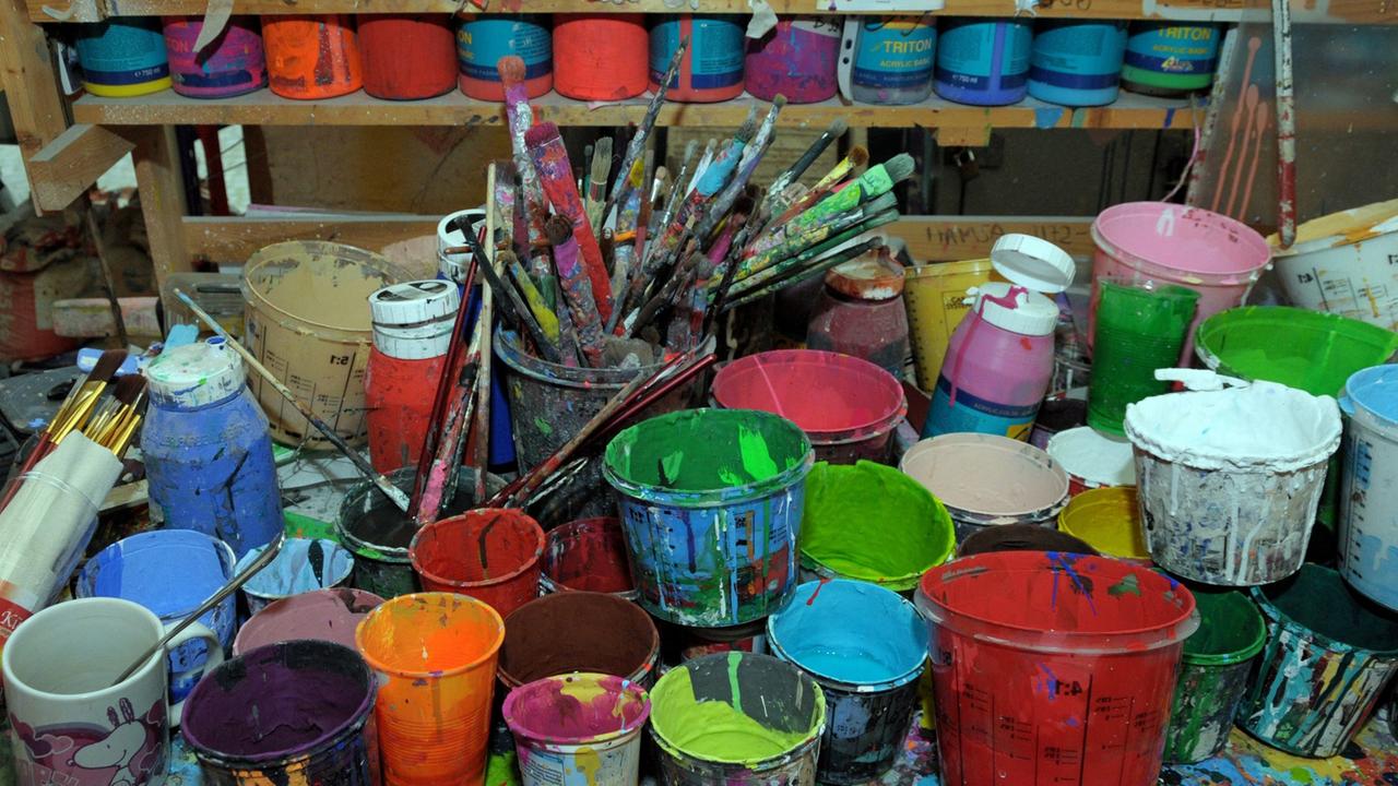 Farbtöpfe und Pinsel stehen in einem Atelier. Farbtöpfe und Pinsel stehen in einem Atelier.