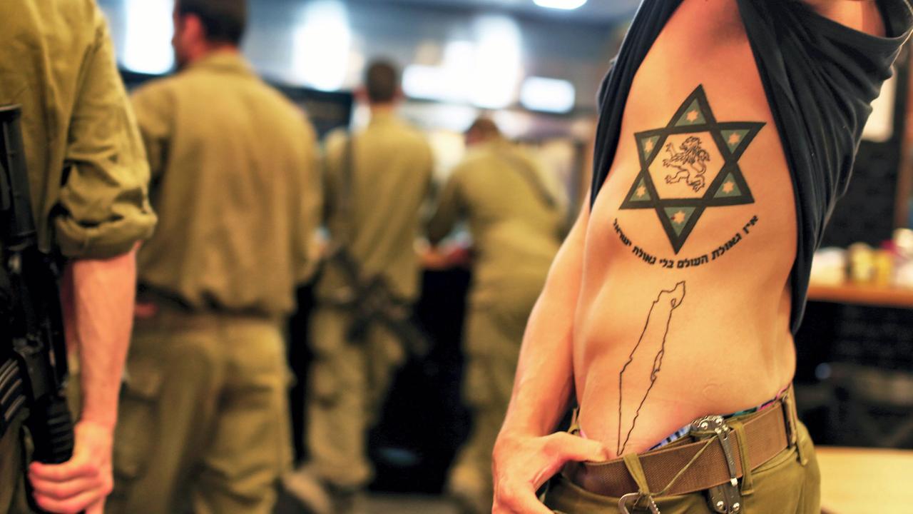 Ein israelischer Soldat zeigt seine Pro-Israel Tätowierung, während er am 26.7.2014 in Sderot vor einem Restaurant wartet. Ein israelischer Soldat zeigt seine Pro-Israel Tätowierung, während er am 26.7.2014 in Sderot vor einem Restaurant wartet.