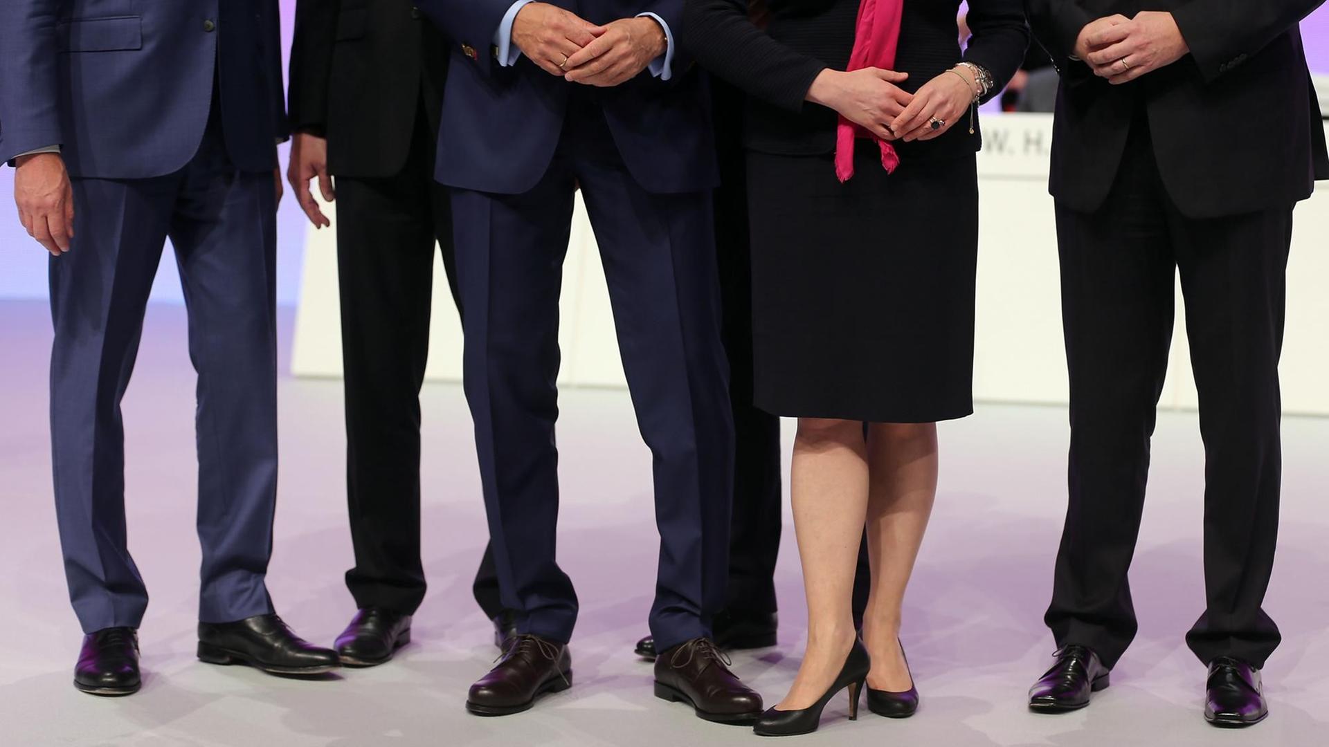 Mehrere männliche und ein weibliches Vorstandsmitglied stehen am 15.05.2014 in Köln auf einer Hauptversammlung zusammen auf dem Podium.