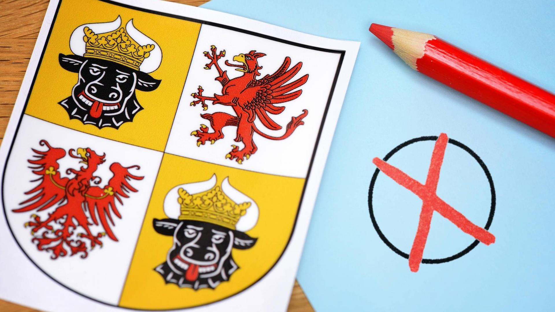 Landeswappen von Mecklenburg Vorpommern. Daneben liegt ein roter Stift, welcher ein Kreuz in einen Kreis zeichnet. Landeswappen von Mecklenburg Vorpommern. Daneben liegt ein roter Stift, welcher ein Kreuz in einen Kreis zeichnet.