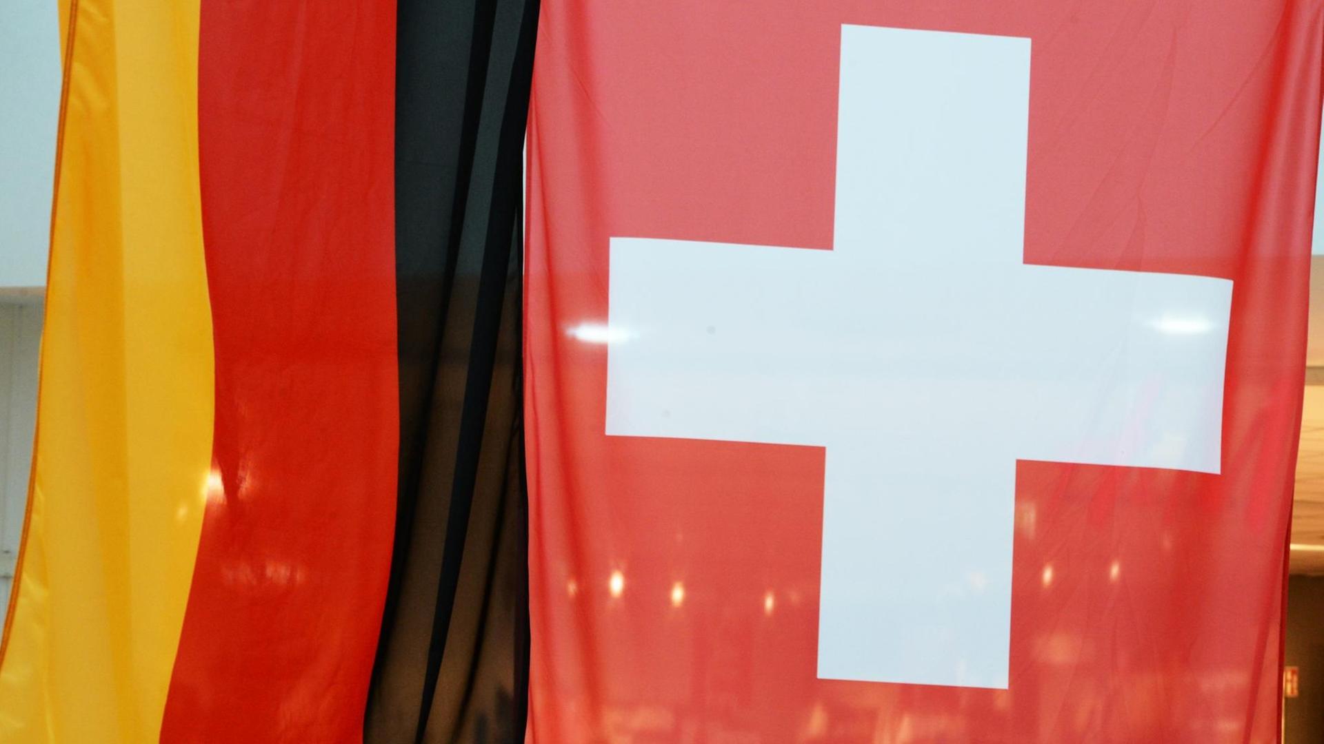 Die deutsche (links) und die Schweizer Flagge (rechts) hängen im Rhein-Center in Weil am Rhein in Baden-Württemberg. Die deutsche (links) und die Schweizer Flagge (rechts) hängen im Rhein-Center in Weil am Rhein in Baden-Württemberg.
