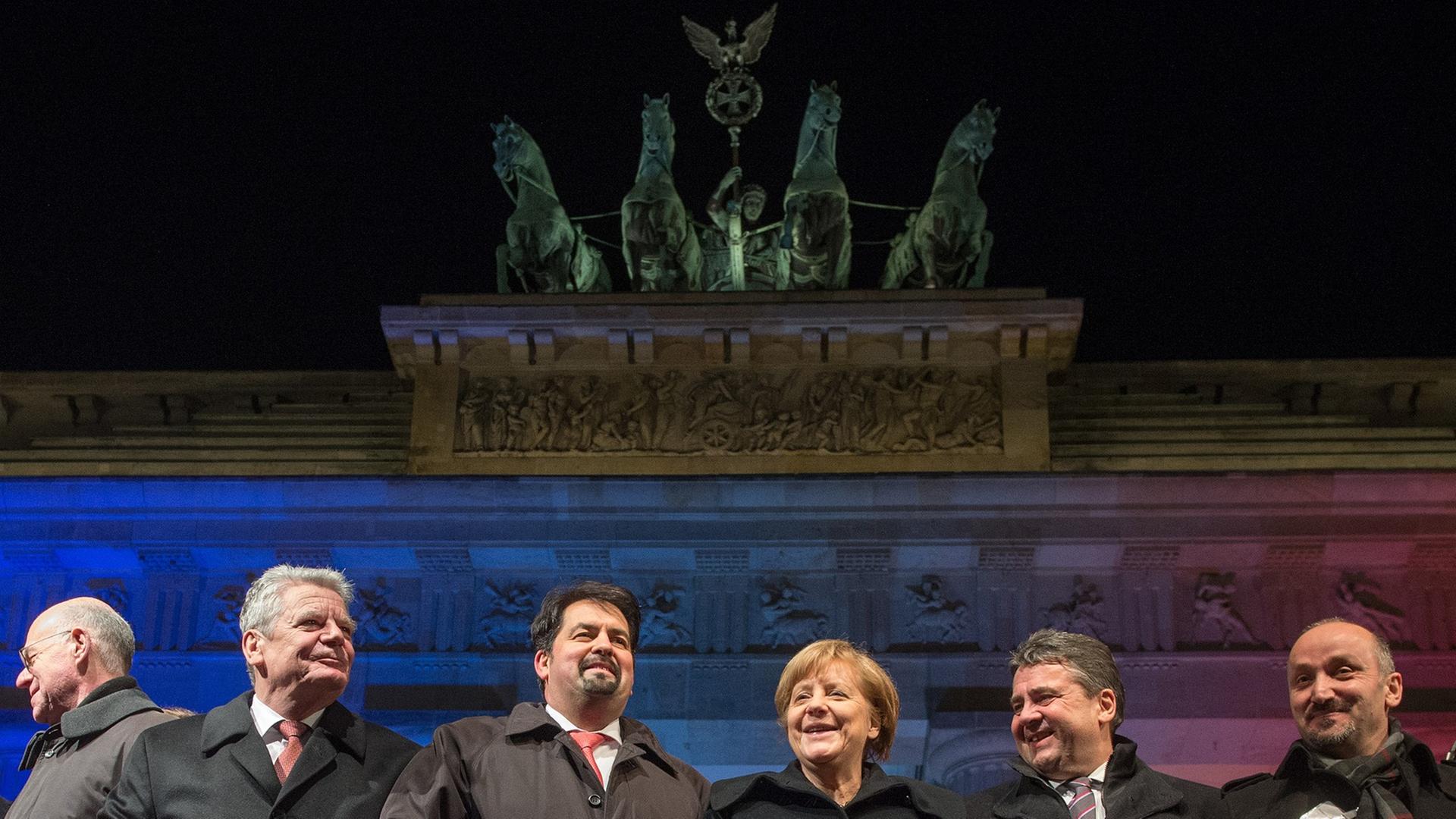 Bundestagspräsident Norbert Lammer (CDU), Bundespräsident Joachim Gauck, der Vorsitzende des Zentralrates der Muslime in Deutschland, Aiman Mazyek, Bundeskanzlerin Angela Merkel (CDU), Bundeswirtschaftsminister Sigmar Gabriel (SPD) und der Vorsitzender der Türkischen Gemeinde zu Berlin, Bekir Yilmaz, haken sich bei einer Mahnwache für die Opfer der Anschläge in Frankreich vor dem Brandenburger Tor in Berlin unter. Bundestagspräsident Norbert Lammer (CDU), Bundespräsident Joachim Gauck, der Vorsitzende des Zentralrates der Muslime in Deutschland, Aiman Mazyek, Bundeskanzlerin Angela Merkel (CDU), Bundeswirtschaftsminister Sigmar Gabriel (SPD) und der Vorsitzender der Türkischen Gemeinde zu Berlin, Bekir Yilmaz, haken sich bei einer Mahnwache für die Opfer der Anschläge in Frankreich vor dem Brandenburger Tor in Berlin unter.