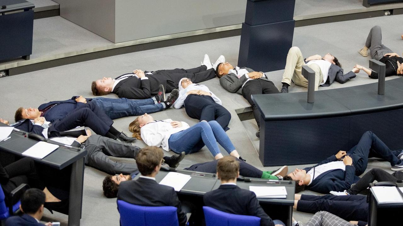 Teilnehmer einer Protestaktion für Klimagerechtigkeit von Fridays For Future liegen im Juni 2019 im Plenarsaal des Bundestages auf dem Boden.