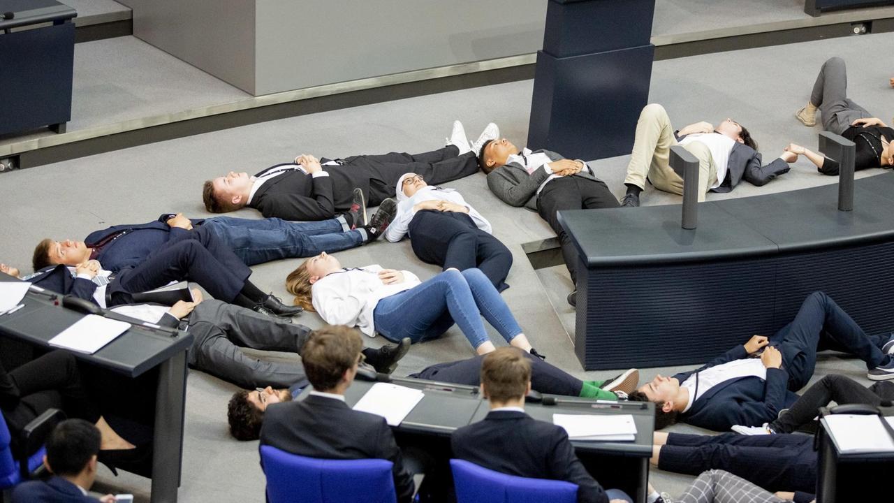 Teilnehmer einer Protestaktion für Klimagerechtigkeit von Fridays For Future liegen im Juni 2019 im Plenarsaal des Bundestages auf dem Boden. Teilnehmer einer Protestaktion für Klimagerechtigkeit von Fridays For Future liegen im Juni 2019 im Plenarsaal des Bundestages auf dem Boden.