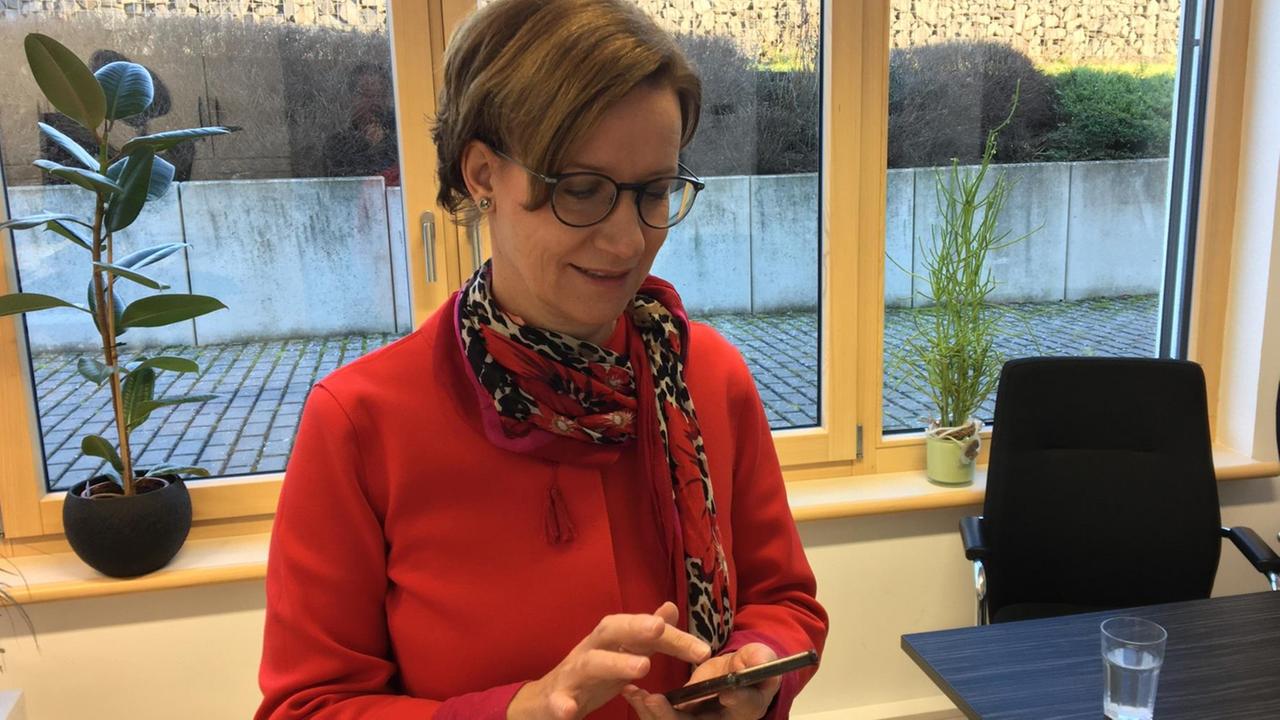 Bürgermeisterin Marion Frohnapfel guckt auf ihr Handy. Bürgermeisterin Marion Frohnapfel guckt auf ihr Handy.