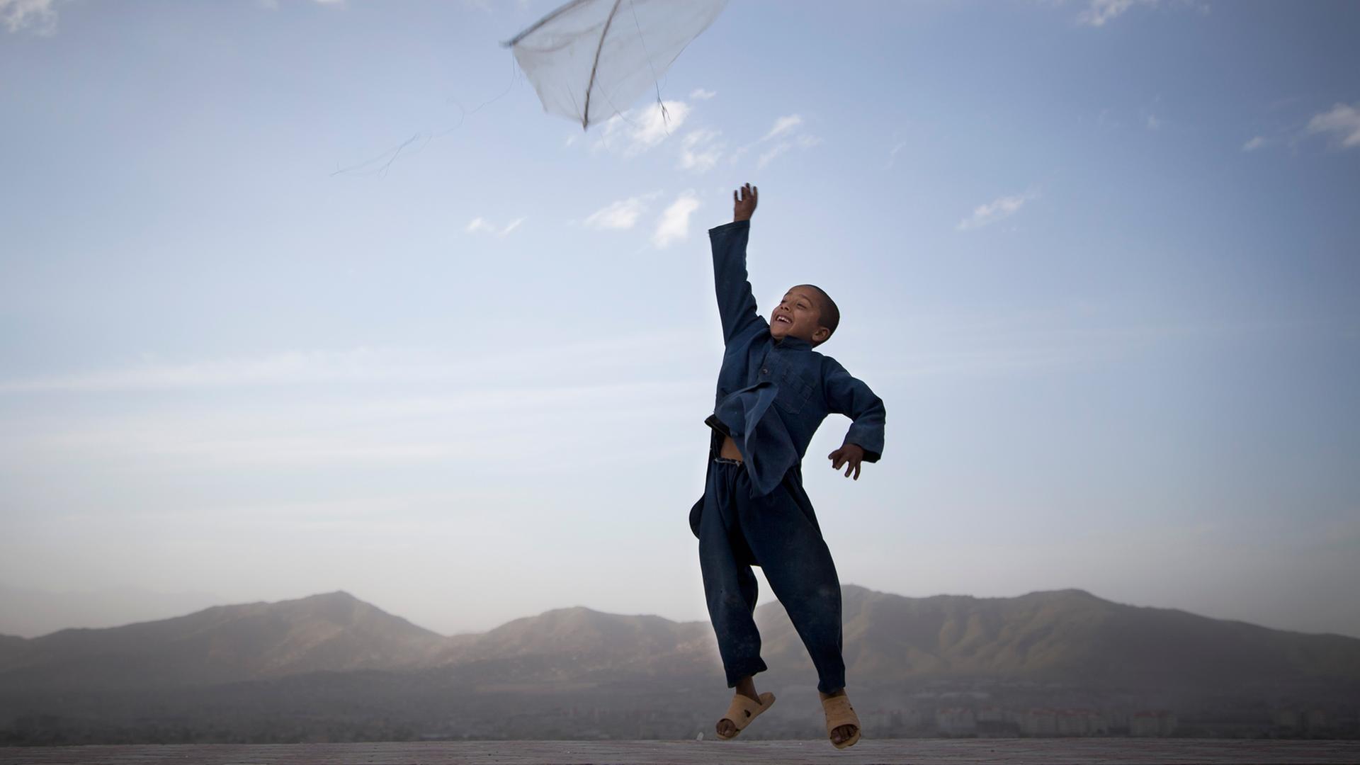 Ein Junge wirft am Rande Kabuls einen Drachen in die Luft.