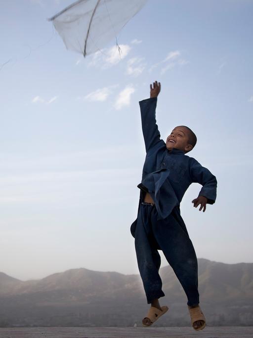 Ein Junge wirft am Rande Kabuls einen Drachen in die Luft.