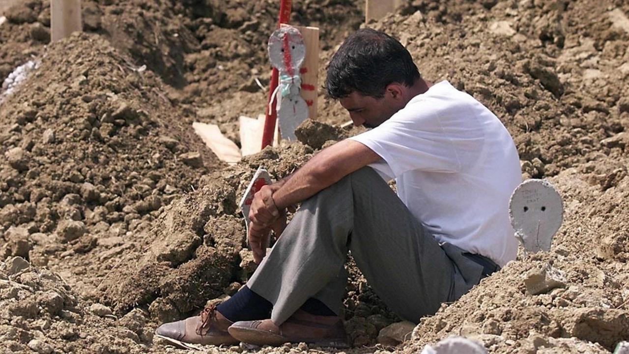 A man meditates on a grave 21 August 1999 at the Yalova cemetery (south of Istanbul) after the burial of victims of the devastating earthquake that hit Turkey 17 August. The death toll of the quake stands over 12.000 dead and 33.500 wounded according to figures released today by the Turkish government crisis center. (ELECTRONIC ) dpa | A man meditates on a grave 21 August 1999 at the Yalova cemetery (south of Istanbul) after the burial of victims of the devastating earthquake that hit Turkey 17 August. The death toll of the quake stands over 12.000 dead and 33.500 wounded according to figures released today by the Turkish government crisis center. (ELECTRONIC ) dpa |