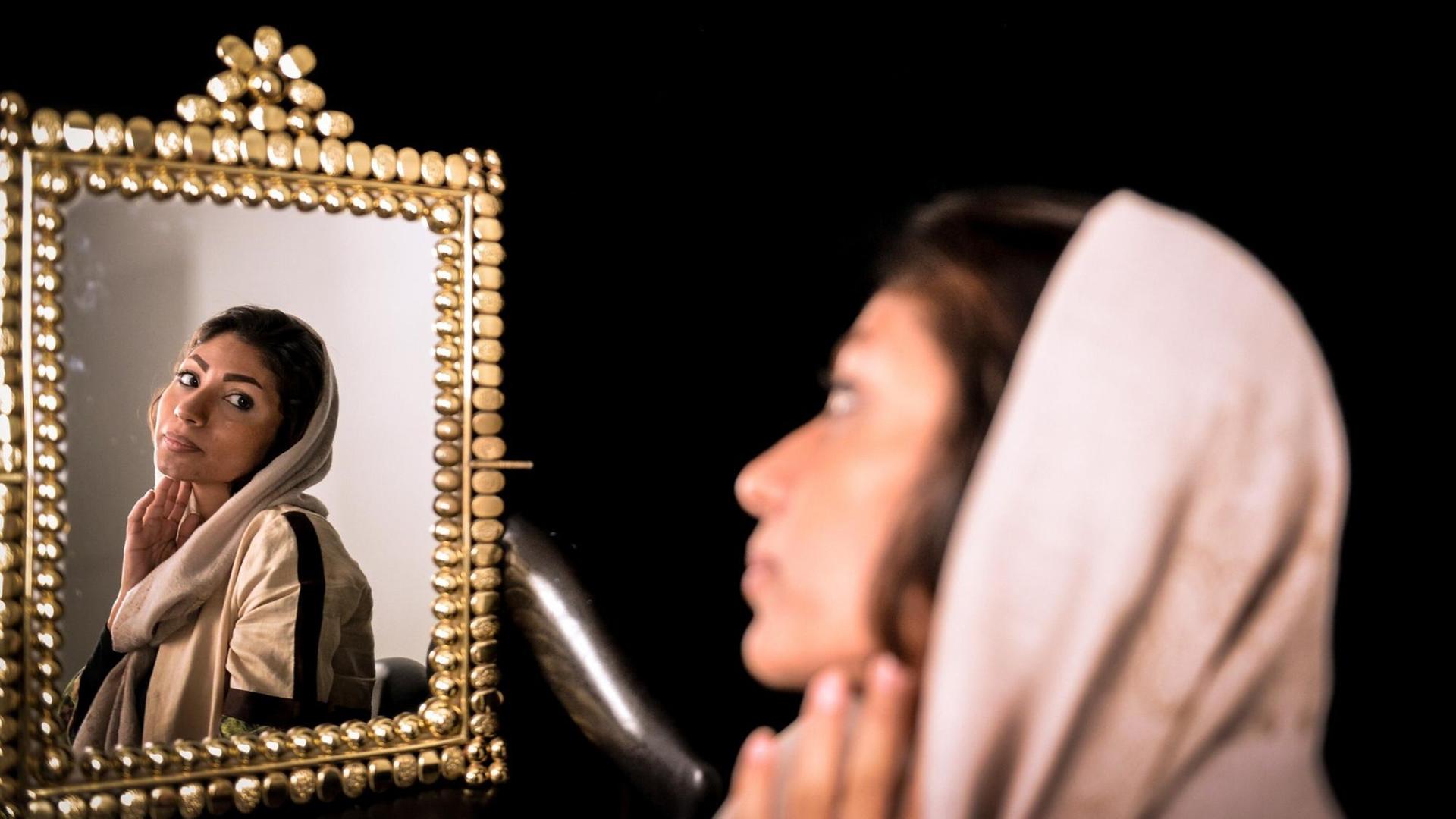 Eine junge Iranerin betrachtet ihr Spiegelbild, während sie auf eine Voruntersuchung für einen plastischen Eingriff wartet.