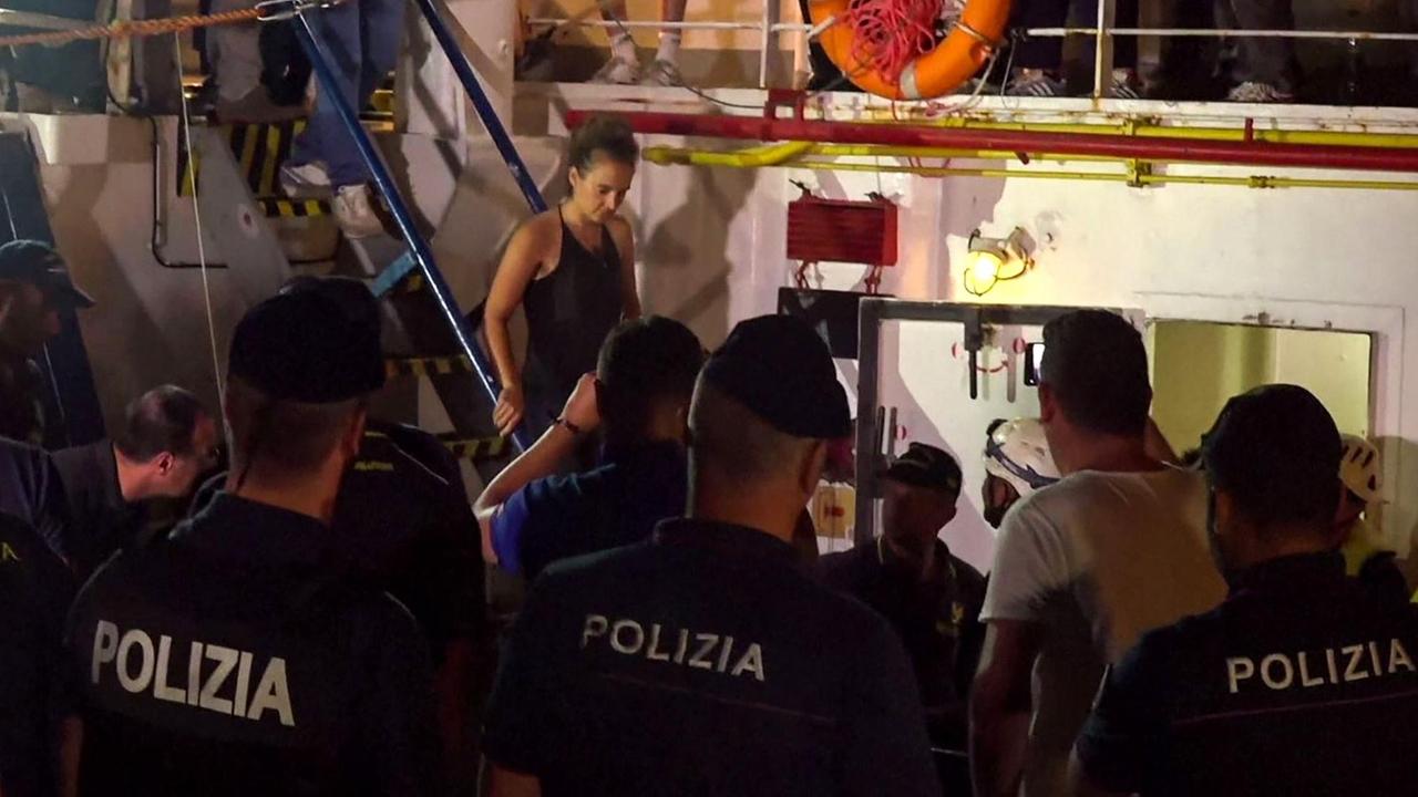 Die Kapitänin des Flüchtlingsrettungsschiffs "Sea-Watch 3" wird von der Polizei festgenommen. Die Kapitänin des Flüchtlingsrettungsschiffs "Sea-Watch 3" wird von der Polizei festgenommen.