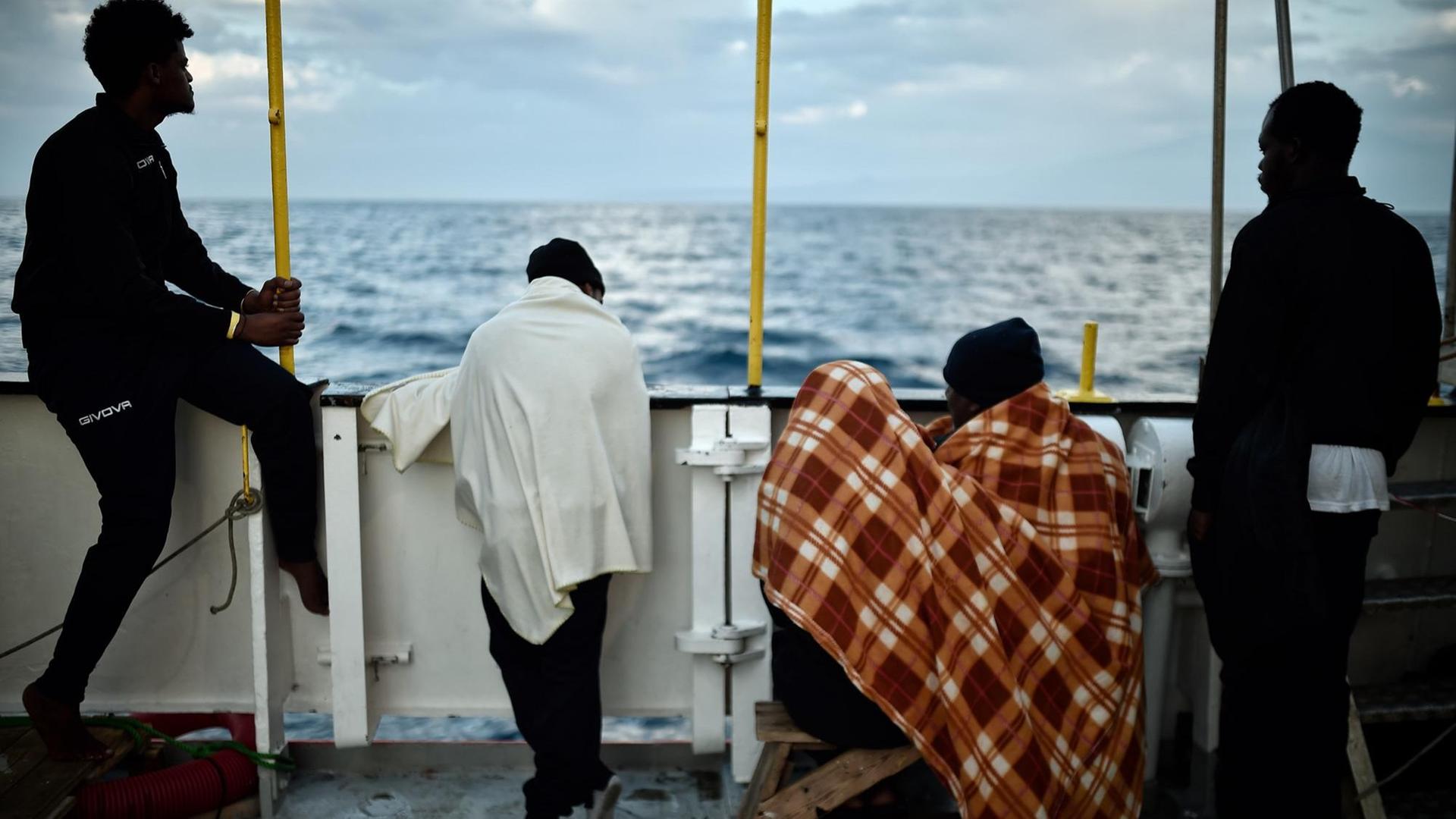Afrikaner stehen an der Reling eines Schiffes, mit dem Rücken zur Kamera. Afrikaner stehen an der Reling eines Schiffes, mit dem Rücken zur Kamera.
