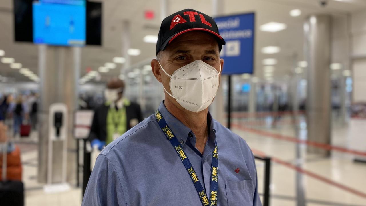 John Selden steht am Flughafen und trägt eine Maske John Selden steht am Flughafen und trägt eine Maske