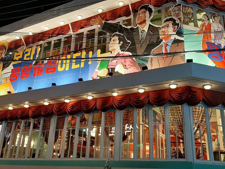 Auf der Fassade des Pyeongyang Pub wird die Arbeiterklasse glorifiziert