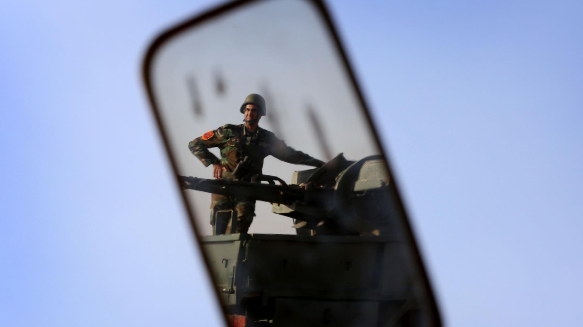 Ein kurdischer Peschmerga-Kämpfer spiegelt sich in einem Rückspiegel.