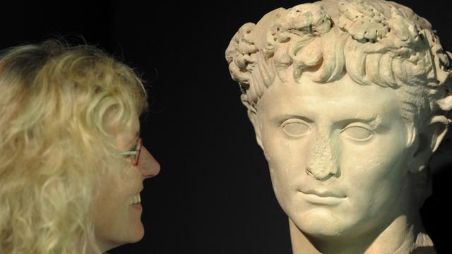 Eine Museumsmitarbeiterin betrachtet am Donnerstag (14.05.2009) in Haltern am See das Porträt des römischen Kaisers Augustus.