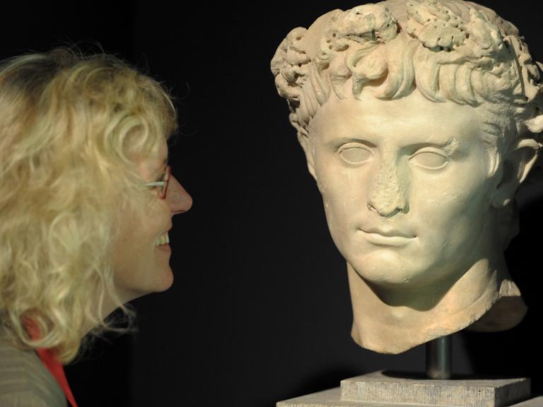 Eine Museumsmitarbeiterin betrachtet am Donnerstag (14.05.2009) in Haltern am See das Porträt des römischen Kaisers Augustus.