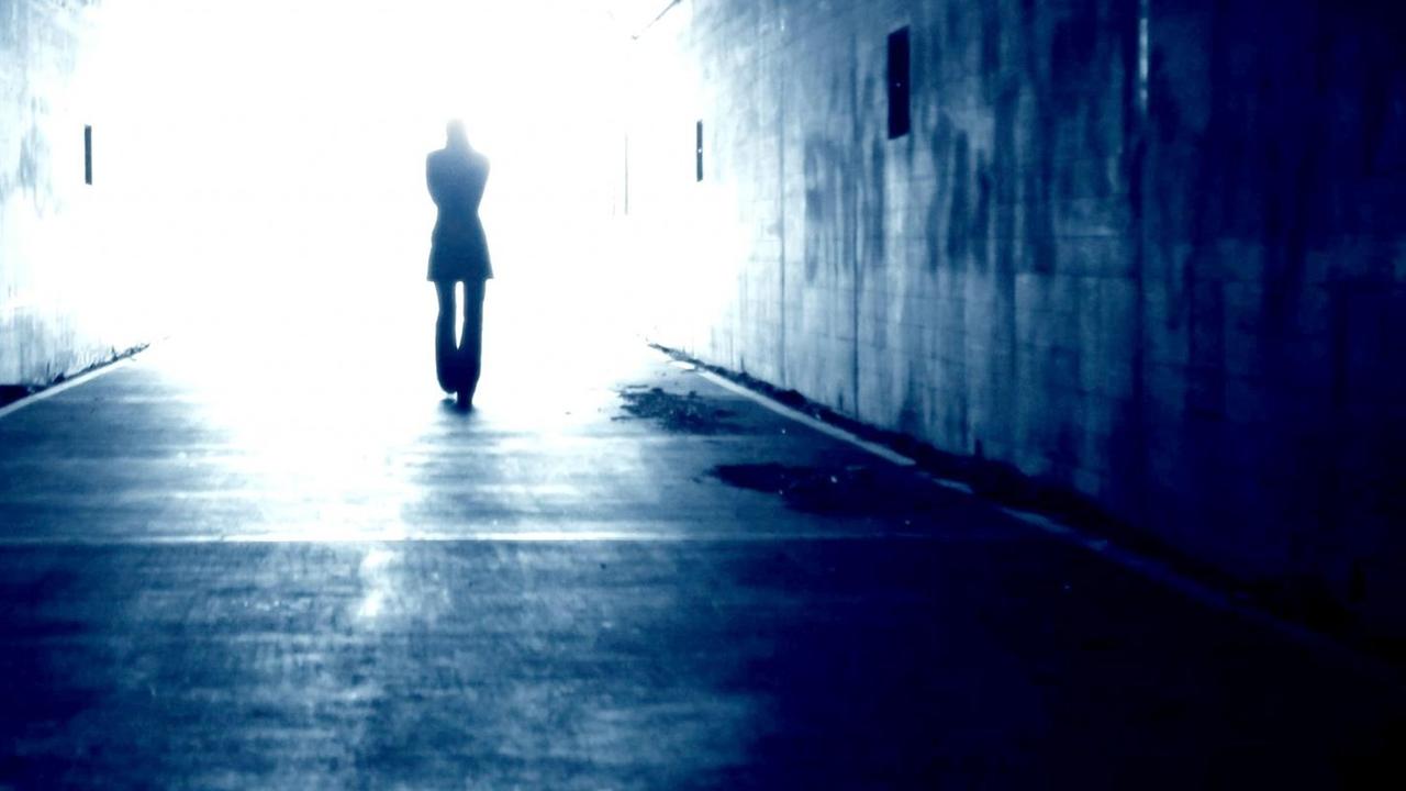 Schattenriss eines Mannes, der durch einen Tunnel ins Licht geht. Schattenriss eines Mannes, der durch einen Tunnel ins Licht geht.