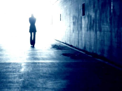 Schattenriss eines Mannes, der durch einen Tunnel ins Licht geht.