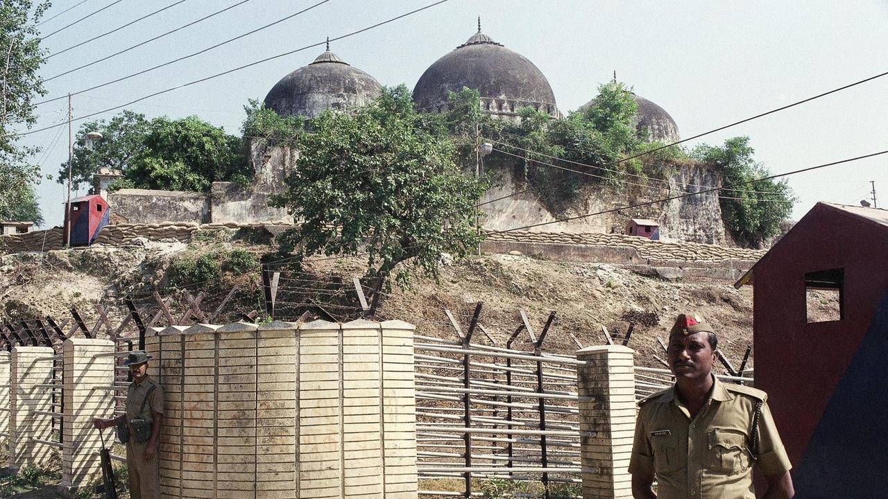 auf einem durch einen Zaun abgesperrten Hügel sind die Türme einer Moschee zu sehen. Vor dem Zaun steht ein Sicherheitsmann.. auf einem durch einen Zaun abgesperrten Hügel sind die Türme einer Moschee zu sehen. Vor dem Zaun steht ein Sicherheitsmann..