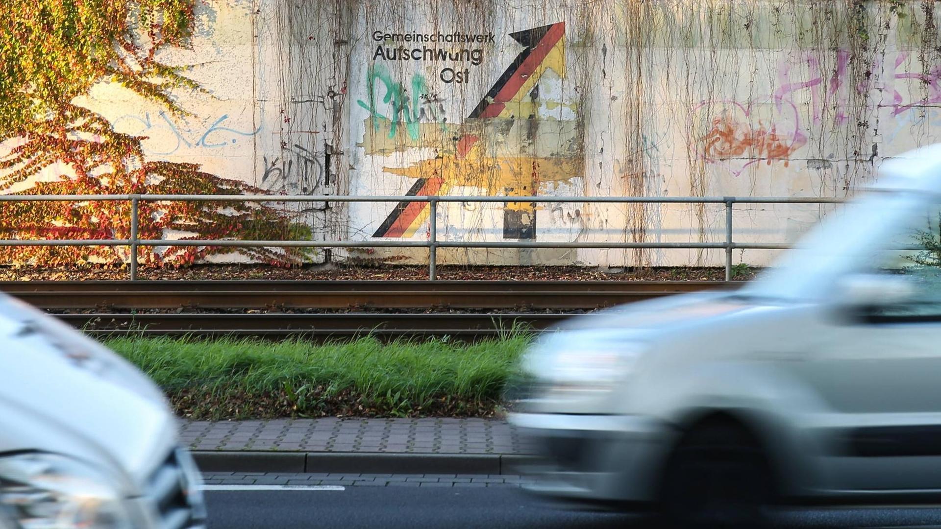 Der Schriftzug "Gemeinschaftswerk Aufschwung Ost" mit Pfeil in den Farben Schwarz, Rot, Gold an einer Mauer in Magdeburg, fotografiert am 30.10.2017.