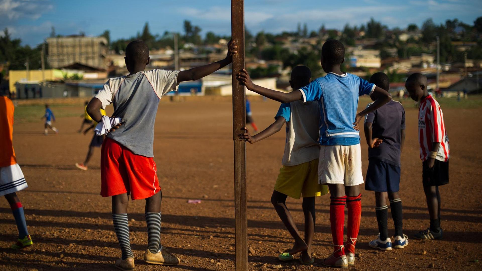 Mehrere Kinder stehen während eines Fußballspiels an den Torpfosten gelehnt. Mehrere Kinder stehen während eines Fußballspiels an den Torpfosten gelehnt.