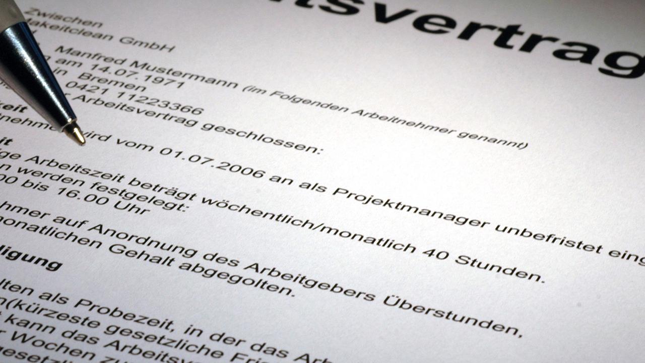 Eine Kugelschreibermiene nähert sich einem Vertragsdokument. Eine Kugelschreibermiene nähert sich einem Vertragsdokument.