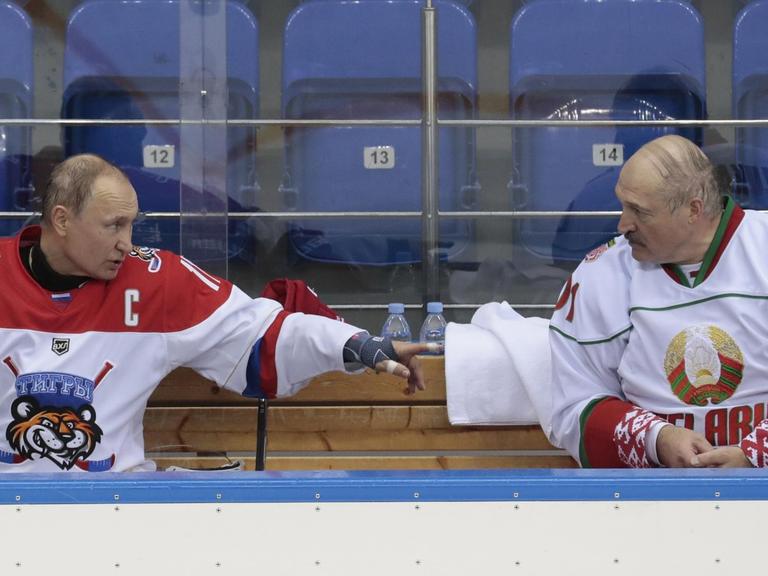 Der russische Präsident Vladimir Putin (L) und der weißrussische Präsident Alexander Lukaschenko sprechen am 15. Februar 2019 in der Shayba-Arena im Schwarzmeerort Sotschi, Russland, während Ihrer gemeinsamen Teilnahme an einem Eishockeyspiel.