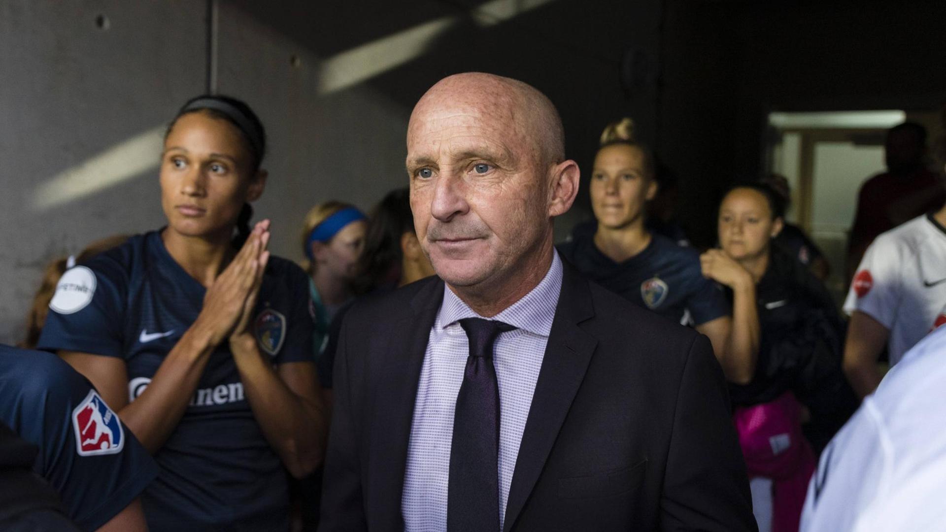 Der Trainer steht vor den Fußballerinnen Der Trainer steht vor den Fußballerinnen