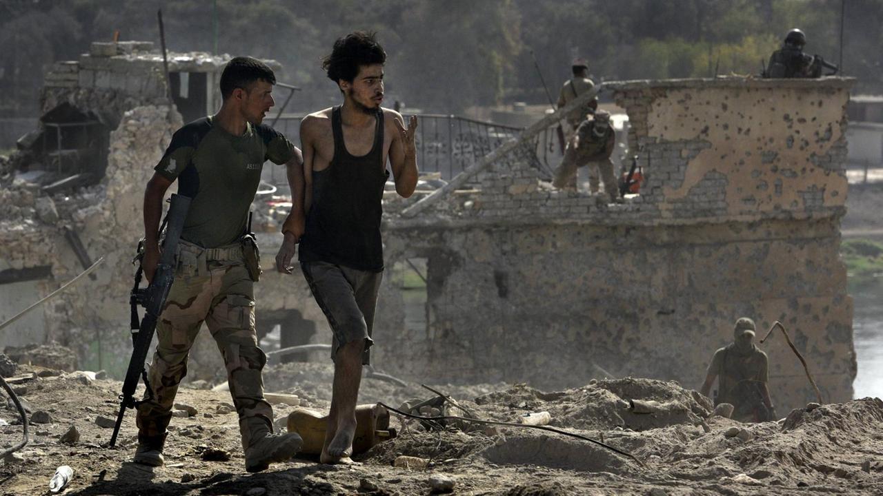 July 18, 2017. Mosul, Iraq: ISIS fighter is led away after surrendering to Iraqi Army soldiers on July 18, 2017 amid ruins of the Old City. July 18, 2017. Mosul, Iraq: ISIS fighter is led away after surrendering to Iraqi Army soldiers on July 18, 2017 amid ruins of the Old City.