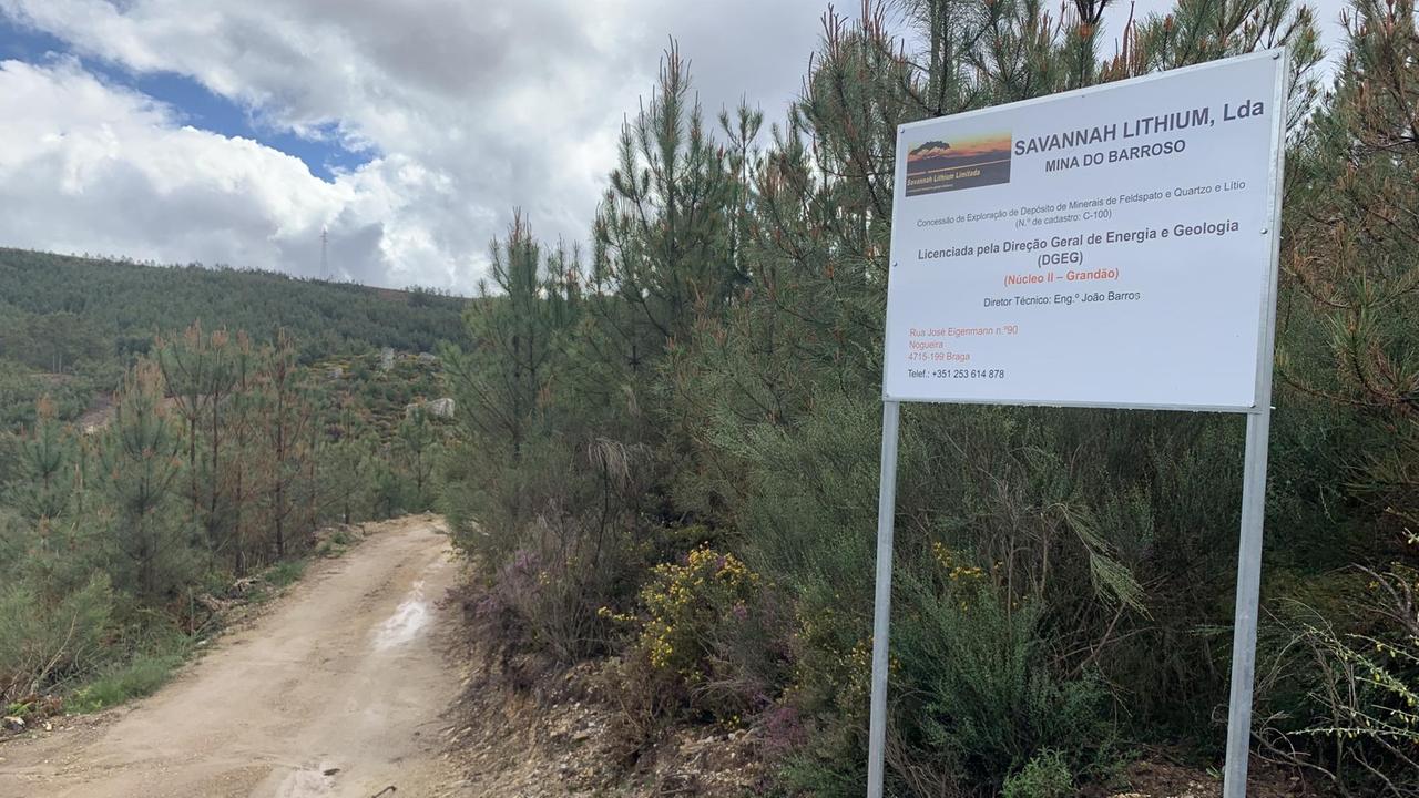 Ein Schild rechts am Eingang zu einer Waldlanschaft, die von einem breiten lehmigen Weg durchschnitten wird. Ein Schild rechts am Eingang zu einer Waldlanschaft, die von einem breiten lehmigen Weg durchschnitten wird.