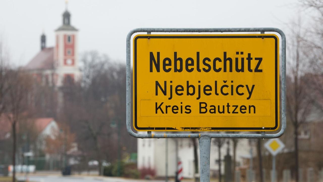 Die Ortstafel von Nebelschütz vor der Pfarrkirche Sankt Martin Die Ortstafel von Nebelschütz vor der Pfarrkirche Sankt Martin