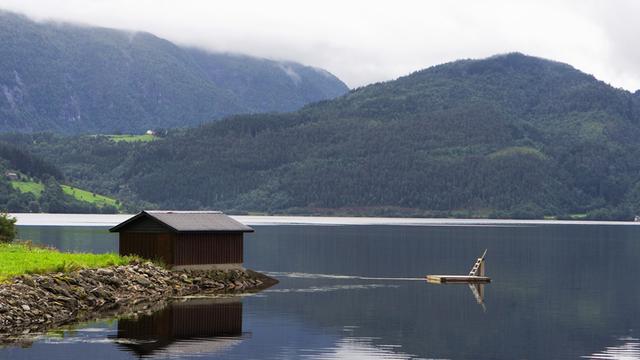 Der Blick auf eine einsame Hütte an einem See.