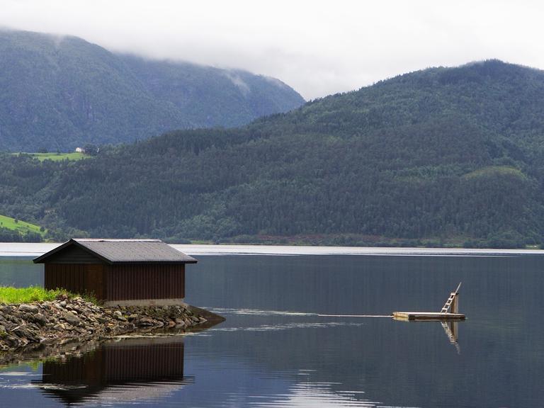 Der Blick auf eine einsame Hütte an einem See.